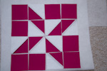 Tento vzor je tvořen ze čtverců a trojúhelníků z bílé a tmavě růžové látky